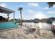 Waterfront backyard with a sandy area, firepit, pergola, and a private boat dock at 744 Spanish Main Dr, Apollo Beach, FL 33572