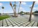 Beautiful waterfront yard with a hammock, palm trees, and modern square tile design at 744 Spanish Main Dr, Apollo Beach, FL 33572