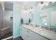 Bright bathroom featuring double sinks with marble countertops, a shower with a bench, and and mirrors at 744 Spanish Main Dr, Apollo Beach, FL 33572