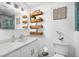 Bright bathroom featuring a framed mirror, floating shelves, and a sink with a marble countertop at 744 Spanish Main Dr, Apollo Beach, FL 33572