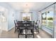 Elegant dining room with a chandelier, seating for six, and a view of the landscaped yard at 744 Spanish Main Dr, Apollo Beach, FL 33572