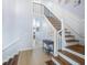Spacious foyer with wood and tile flooring, modern staircase, and stylish decor, creating an inviting entrance at 744 Spanish Main Dr, Apollo Beach, FL 33572