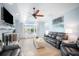 Inviting living room featuring a fireplace, ceiling fan, and comfortable seating with a large bright window at 744 Spanish Main Dr, Apollo Beach, FL 33572