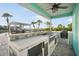 Covered outdoor kitchen boasts a built-in grill, prep area, and island seating overlooking the canal at 744 Spanish Main Dr, Apollo Beach, FL 33572