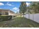 Spacious backyard with a well-maintained lawn, white fence, and mature trees at 7740 Blue Spring Dr, Land O Lakes, FL 34637