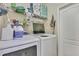 Functional laundry room with modern washer and dryer units and ample storage shelving at 7740 Blue Spring Dr, Land O Lakes, FL 34637