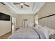 Comfortable bedroom with tray ceilings, wood flooring and a view into other areas of the home at 7740 Blue Spring Dr, Land O Lakes, FL 34637