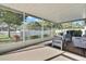 Relaxing screened patio with modern outdoor furniture and a view of the fenced yard at 7740 Blue Spring Dr, Land O Lakes, FL 34637