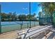 Community tennis courts with fenced enclosure and benches for players and spectators at 7740 Blue Spring Dr, Land O Lakes, FL 34637