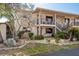 Charming condo exterior featuring stone accents, balconies, and lush landscaping at 9910 Eagles Point Cir # 3, Port Richey, FL 34668