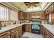 Well-lit kitchen features dark wood cabinetry, white appliances, and tiled countertops at 9910 Eagles Point Cir # 3, Port Richey, FL 34668