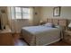 Cozy bedroom featuring a light wood bed frame, laminate floors and a bright window at 1012 Warwick Ct, Sun City Center, FL 33573