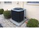 Close-up of a modern home's air conditioning unit, surrounded by manicured landscaping at 1012 Warwick Ct, Sun City Center, FL 33573