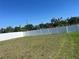 Spacious backyard featuring a well-maintained lawn and a white vinyl fence for added privacy and security at 1038 Ocean Spray Dr, Ruskin, FL 33570