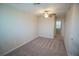 Bright and spacious room with neutral carpet, ceiling fan, and hallway access at 1038 Ocean Spray Dr, Ruskin, FL 33570