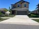 Inviting two-story home with a neutral color scheme, gray garage door, and extended driveway on a sunny day at 1038 Ocean Spray Dr, Ruskin, FL 33570