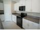 Modern kitchen featuring white cabinets, granite countertops, and black appliances at 1038 Ocean Spray Dr, Ruskin, FL 33570