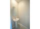 Small powder room with a pedestal sink, oval mirror, and neutral paint at 1038 Ocean Spray Dr, Ruskin, FL 33570