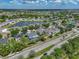 An aerial view of a home in a lakeside community with lush greenery, close to a main road, and nearby neighborhood pool at 11308 Callaway Pond Dr, Riverview, FL 33579