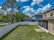 Large backyard with white vinyl fence, screened in patio and lush green grass at 11308 Callaway Pond Dr, Riverview, FL 33579