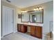 Bright bathroom featuring a double vanity with wood cabinets and a large framed mirror at 11308 Callaway Pond Dr, Riverview, FL 33579