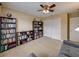 Cozy bedroom featuring multiple bookshelves and a ceiling fan at 11308 Callaway Pond Dr, Riverview, FL 33579