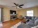 Comfortable living room with a stone fireplace, ceiling fan, hardwood floors and access to a screened patio at 11308 Callaway Pond Dr, Riverview, FL 33579