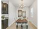 Bright dining room featuring a modern light fixture, stylish artwork, and a natural wood table with seating for four at 12017 Grand Kempston Dr, Gibsonton, FL 33534