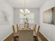 Formal dining area features a modern chandelier, seating for six, and stylish decor, perfect for entertaining at 12017 Grand Kempston Dr, Gibsonton, FL 33534