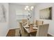 Contemporary dining room showcases a modern chandelier, seating for six, and elegant wall art, ideal for gatherings at 12017 Grand Kempston Dr, Gibsonton, FL 33534