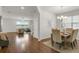 Open-concept dining area with hardwood floors, a chandelier, and views of the adjacent living area at 12017 Grand Kempston Dr, Gibsonton, FL 33534