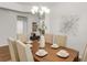 Open dining area featuring a dark wood table with seating for six, modern decor, and an elegant chandelier at 12017 Grand Kempston Dr, Gibsonton, FL 33534