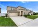Two-story home featuring a two-car garage and landscaped front yard at 12017 Grand Kempston Dr, Gibsonton, FL 33534
