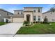 Two-story home featuring neutral color scheme, attached garage, and well-maintained landscaping at 12017 Grand Kempston Dr, Gibsonton, FL 33534