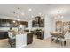 Well-equipped kitchen with stainless steel appliances, a spacious island, and granite counters, connecting to dining area at 12017 Grand Kempston Dr, Gibsonton, FL 33534