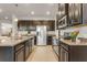 Spacious kitchen boasts stainless steel appliances, dark wood cabinetry, and stone countertops at 12017 Grand Kempston Dr, Gibsonton, FL 33534