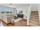 Open-concept living room features a staircase, hardwood floors, and a large window, creating a bright, welcoming space at 12017 Grand Kempston Dr, Gibsonton, FL 33534