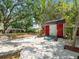 Backyard with a small storage shed, pea gravel ground cover, brick paver path, and some landscaping at 13556 Lake Magdalene Dr, Tampa, FL 33613