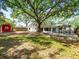 Sprawling backyard with mature trees, a brick paver patio, and a small storage shed at 13556 Lake Magdalene Dr, Tampa, FL 33613