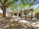 A brick paver patio off the back of the home with a large pergola and a big shade tree at 13556 Lake Magdalene Dr, Tampa, FL 33613