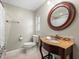 Well-lit bathroom features a round mirror, and granite countertop vanity over tile flooring at 13556 Lake Magdalene Dr, Tampa, FL 33613