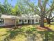 Beautiful front lawn featuring a well-maintained garden, mature trees, and a brick-accented home at 13556 Lake Magdalene Dr, Tampa, FL 33613