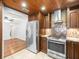Updated kitchen with stainless steel fridge and stove, complemented by custom cabinets and wood-paneled ceiling at 13556 Lake Magdalene Dr, Tampa, FL 33613