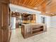 Spacious open kitchen featuring a large center island, wooden ceiling, and modern appliances at 13556 Lake Magdalene Dr, Tampa, FL 33613