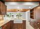 Bright kitchen with a farmhouse sink, granite counters, custom cabinetry, and a view of the backyard at 13556 Lake Magdalene Dr, Tampa, FL 33613