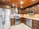 Kitchen showcasing stainless steel appliances, granite countertops, tile backsplash, and custom wood ceiling at 13556 Lake Magdalene Dr, Tampa, FL 33613