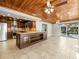 Open kitchen with large center island, wood ceiling, stainless steel appliances, and adjacent living areas at 13556 Lake Magdalene Dr, Tampa, FL 33613