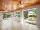 Bright living room featuring tile floors, large windows, and sliding glass doors to the backyard at 13556 Lake Magdalene Dr, Tampa, FL 33613