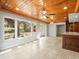 Bright living area with wood ceiling, tile flooring, and scenic backyard views through large windows at 13556 Lake Magdalene Dr, Tampa, FL 33613