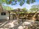 Paver patio features an outdoor pergola with a built-in bench and a table under the shade at 13556 Lake Magdalene Dr, Tampa, FL 33613